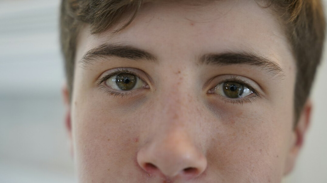 Portrait of a young man with short hair looking at the camera