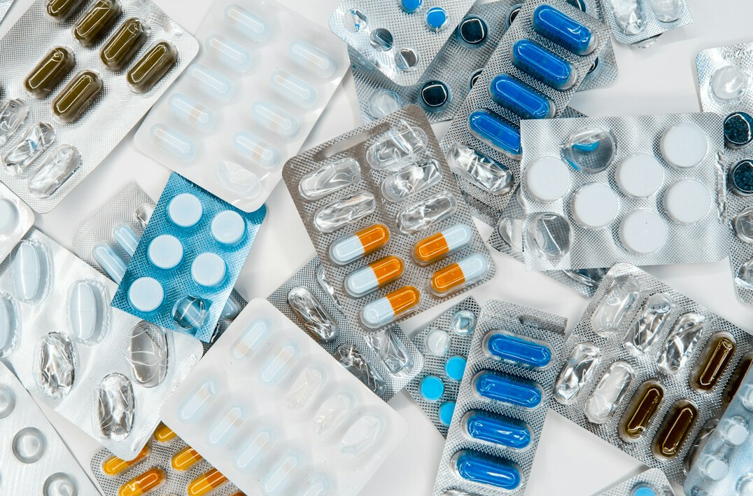 Pills and medicine packages on a light surface